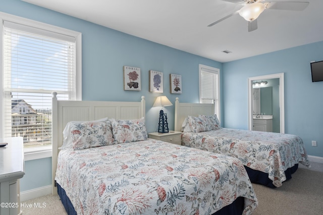 bedroom with carpet, baseboards, ensuite bathroom, and a ceiling fan