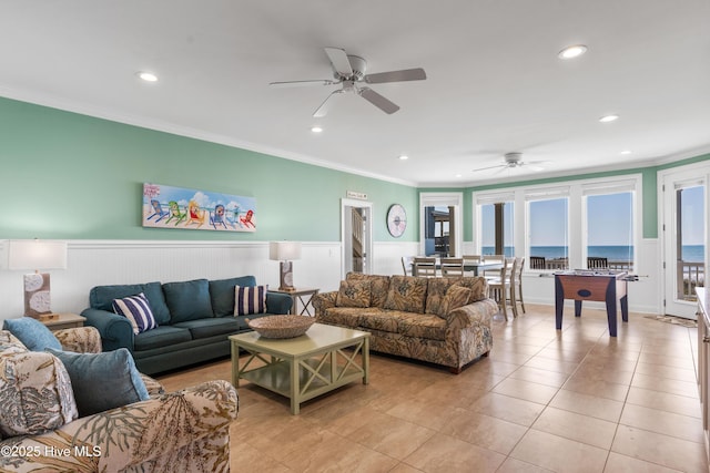 living room with ceiling fan, crown molding, recessed lighting, wainscoting, and light tile patterned flooring