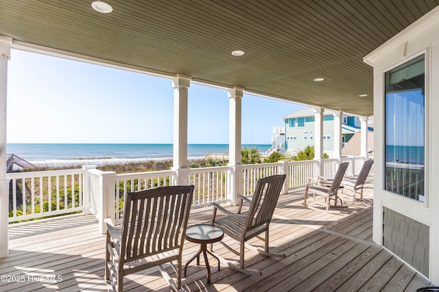 wooden deck featuring view of water and beach