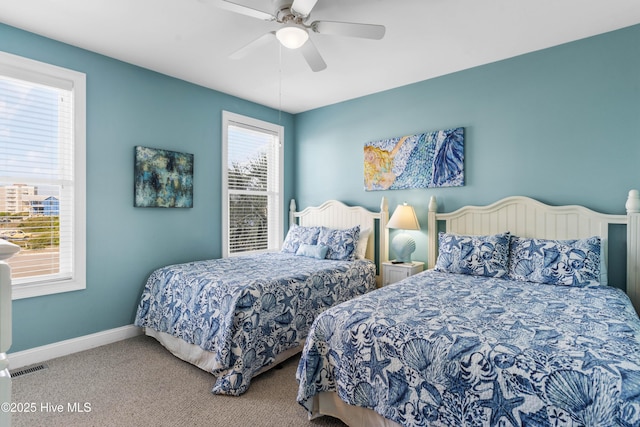 bedroom featuring multiple windows, carpet flooring, baseboards, and a ceiling fan