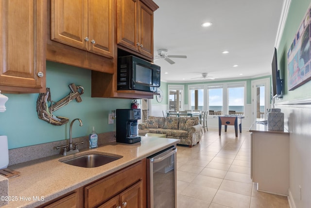 kitchen featuring black microwave, a sink, dishwasher, brown cabinetry, and recessed lighting