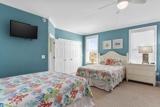 bedroom featuring ornamental molding, light carpet, a closet, and a ceiling fan