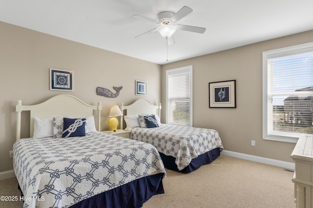 bedroom with carpet floors, baseboards, and multiple windows