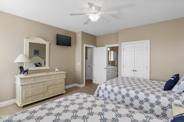 bedroom with carpet floors, baseboards, a closet, a ceiling fan, and ensuite bath