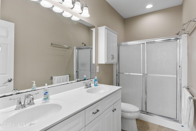 full bath with a stall shower, toilet, double vanity, and tile patterned floors