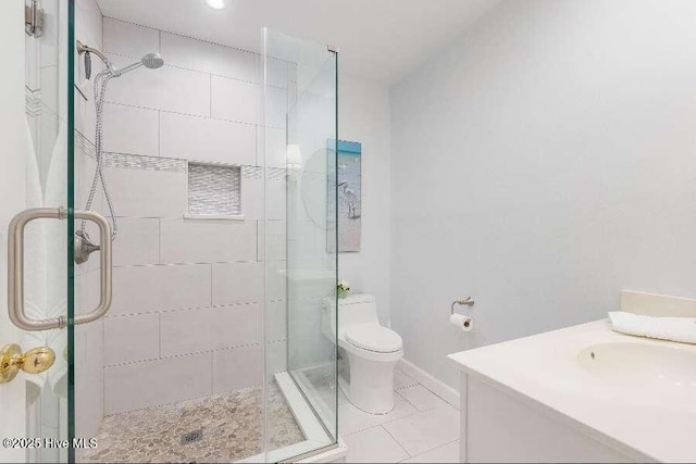 full bath with a stall shower, toilet, tile patterned flooring, and vanity