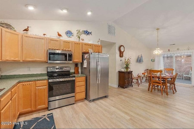 kitchen with appliances with stainless steel finishes, lofted ceiling, light wood-style flooring, a chandelier, and decorative light fixtures
