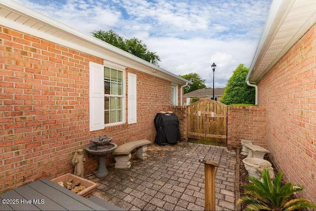 view of patio with a gate and area for grilling