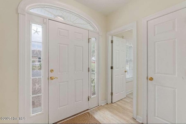 foyer entrance with light wood finished floors and baseboards