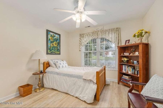 bedroom featuring light wood-style flooring, baseboards, and ceiling fan