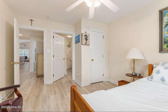bedroom featuring light wood-style floors, baseboards, and a ceiling fan