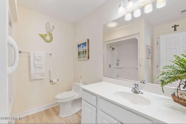 full bath with a shower, toilet, wood finished floors, vanity, and baseboards