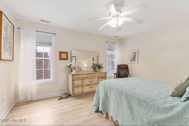 bedroom with light wood finished floors, baseboards, and ceiling fan