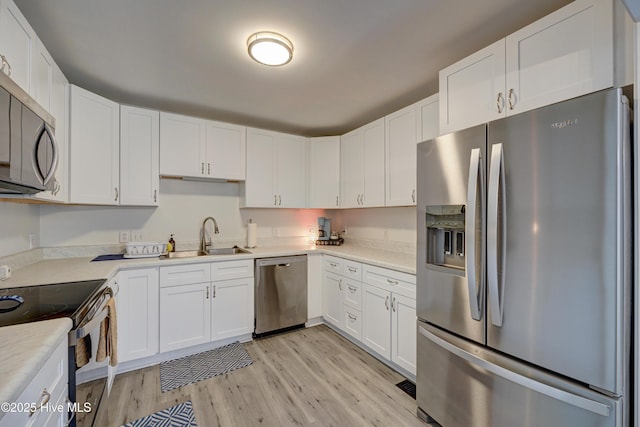 138 Cherokee Trl, Wilmington, NC 28409 - kitchen featuring stainless steel appliances, a sink, light wood-style floors, and white cabinets