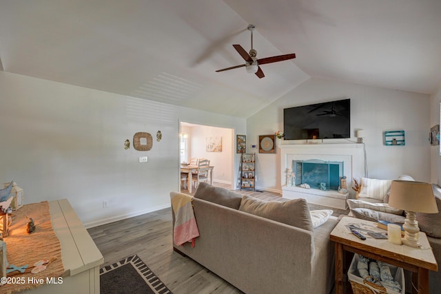 138 Cherokee Trl, Wilmington, NC 28409 - living room with a ceiling fan, wood finished floors, lofted ceiling, a fireplace with raised hearth, and baseboards