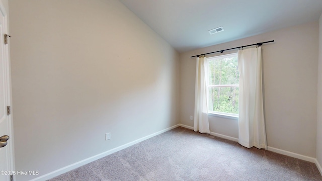 unfurnished room featuring carpet floors, vaulted ceiling, and baseboards
