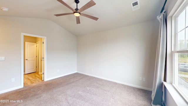 carpeted empty room featuring a ceiling fan, lofted ceiling, and baseboards