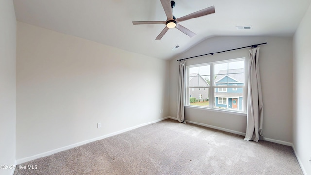 carpeted empty room featuring vaulted ceiling, ceiling fan, and baseboards