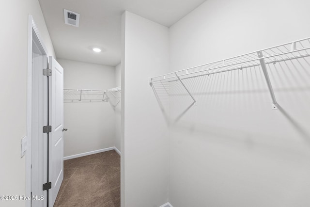 spacious closet with dark carpet
