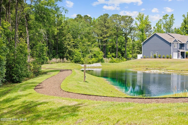 surrounding community with a water view and a yard