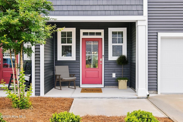 property entrance featuring covered porch and a garage