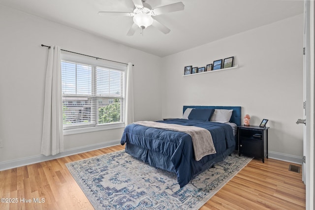 bedroom with wood finished floors, baseboards, and a ceiling fan