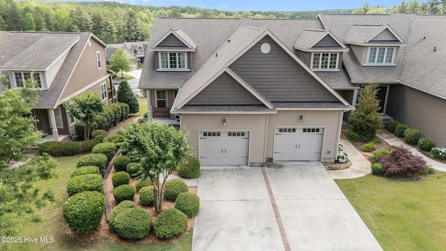 view of front of house with driveway, a front lawn, and a shingled roof