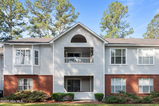 townhome / multi-family property featuring brick siding and a balcony