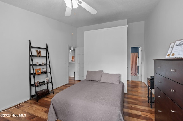 bedroom with wood finished floors, connected bathroom, and ceiling fan