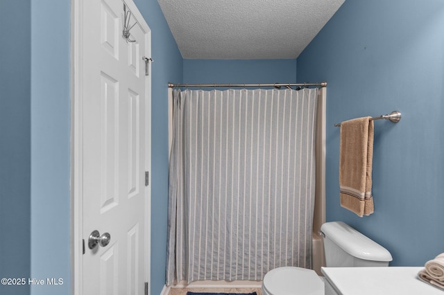 full bathroom featuring toilet, a textured ceiling, and vanity