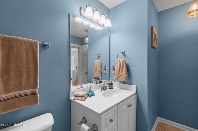 bathroom featuring toilet, vanity, and tile patterned floors