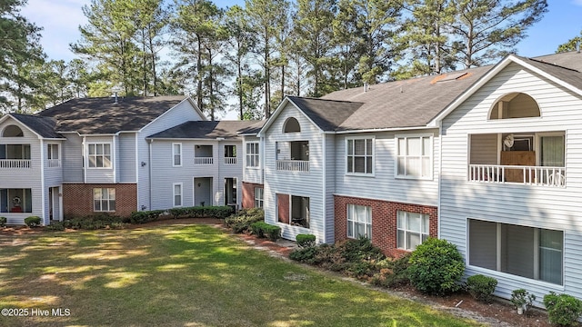 view of front of house featuring brick siding and a front lawn