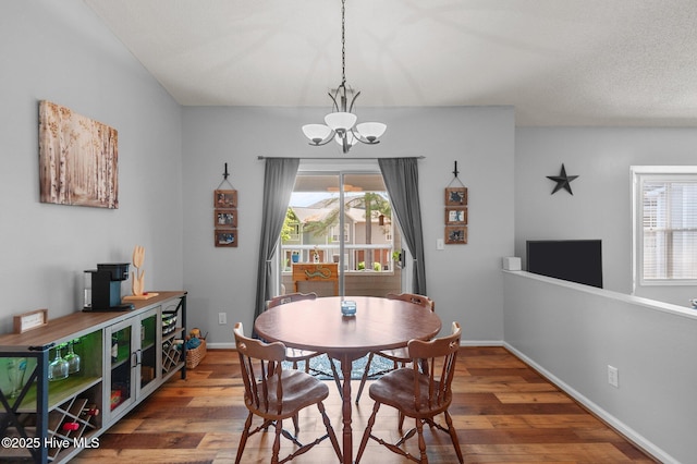 dining area with a chandelier, wood finished floors, and baseboards