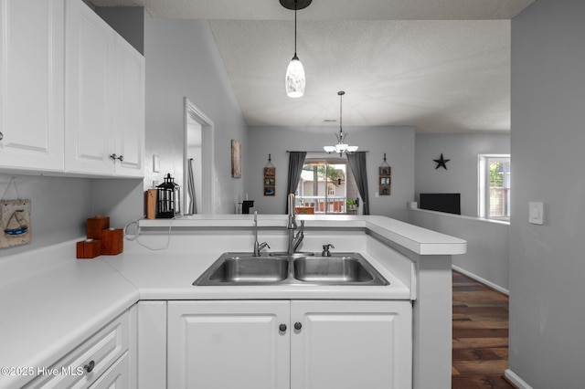 kitchen featuring a sink, a peninsula, plenty of natural light, and open floor plan