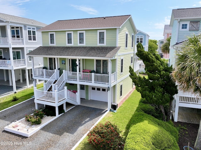 118 Clippership Dr, Holden Beach, NC 28462 - raised beach house with asphalt driveway, a garage, roof with shingles, a porch, and stairs