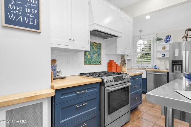 114 N Bonner St, Washington, NC 27889 - kitchen featuring stainless steel appliances, blue cabinetry, white cabinetry, butcher block countertops, and tasteful backsplash