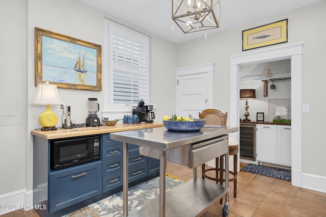 114 N Bonner St, Washington, NC 27889 - dining space with wine cooler, a chandelier, light tile patterned floors, and baseboards