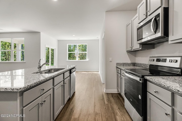 135 Legare St Lot 252, Wilmington, NC 28411 - kitchen featuring stainless steel appliances, gray cabinets, dark wood-type flooring, light stone counters, and an island with sink