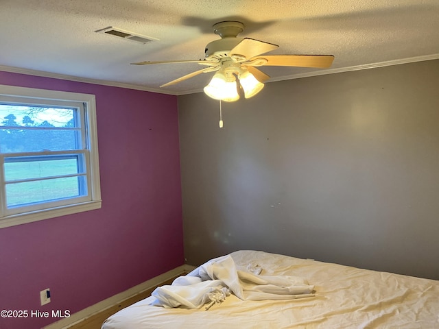 bedroom with crown molding, a textured ceiling, ceiling fan, and baseboards