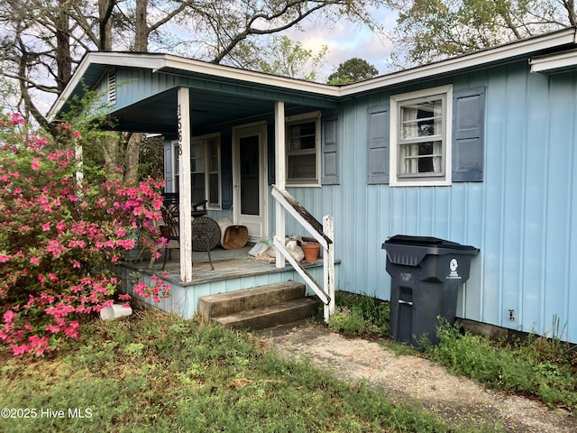 entrance to property with board and batten siding and a porch