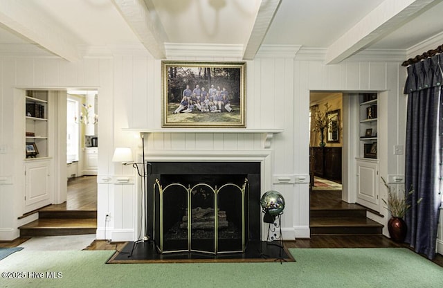 detailed view of wood finished floors, a fireplace with flush hearth, beamed ceiling, crown molding, and a decorative wall