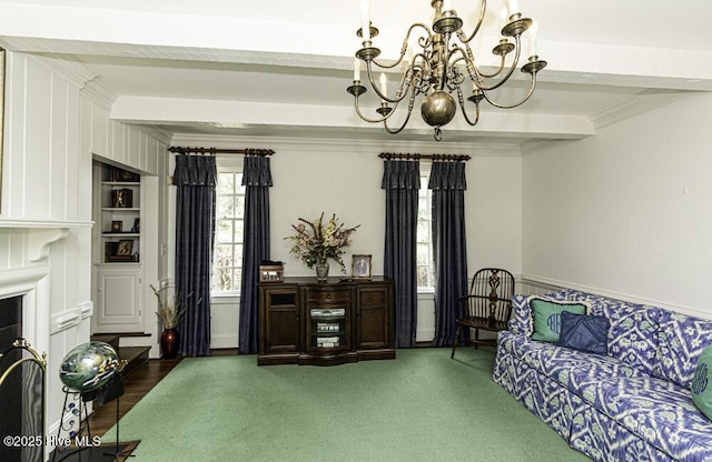 living area with a chandelier, ornamental molding, and built in shelves