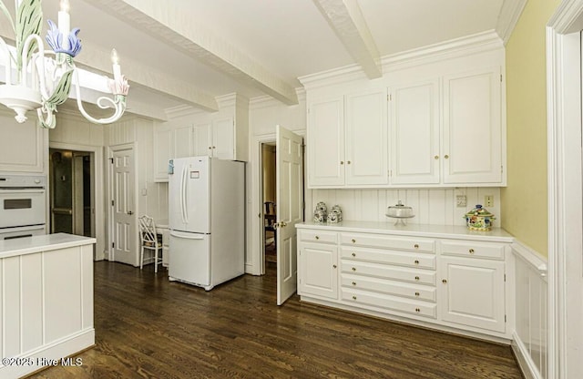 kitchen with white appliances, beam ceiling, light countertops, a chandelier, and white cabinetry