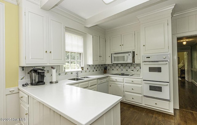 kitchen with white appliances, a sink, a peninsula, beam ceiling, and dark wood-style floors