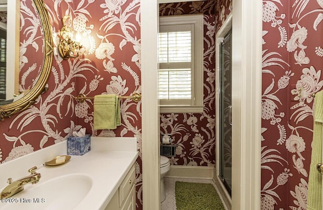 full bathroom with wallpapered walls, toilet, a stall shower, tile patterned floors, and vanity