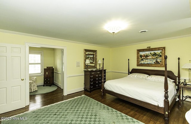 bedroom with ornamental molding, wood finished floors, and baseboards