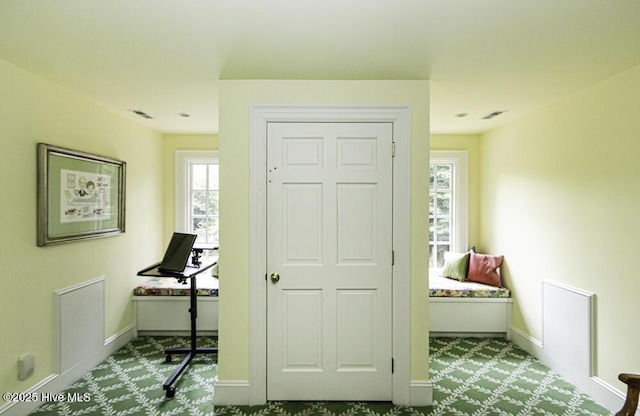 doorway to outside featuring baseboards and carpet flooring