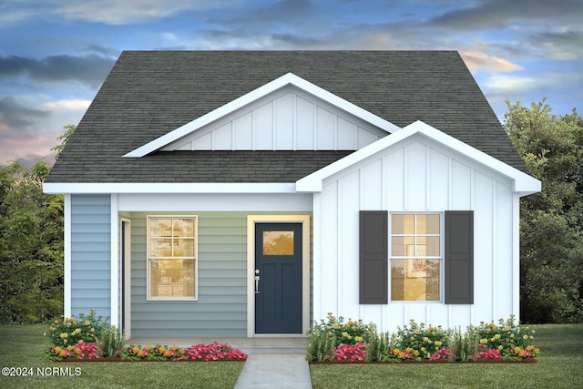 view of front facade with roof with shingles and board and batten siding