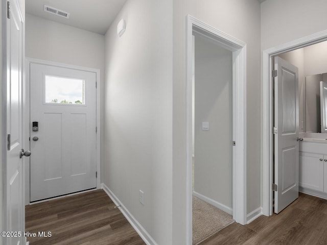 entryway with dark wood-type flooring and baseboards