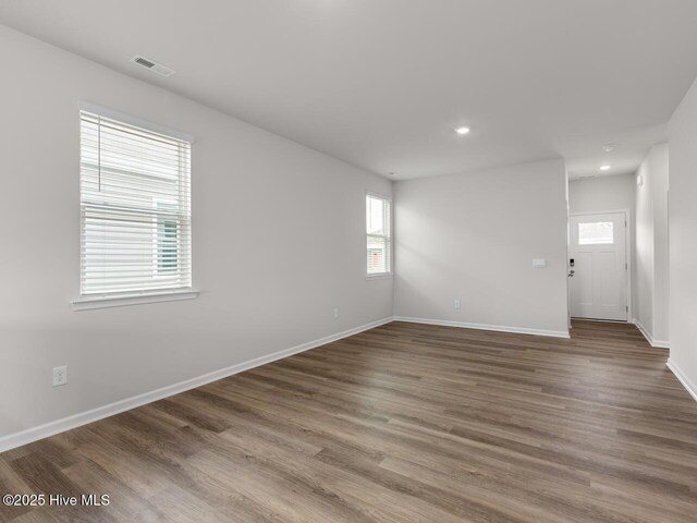 spare room with wood finished floors, baseboards, and recessed lighting